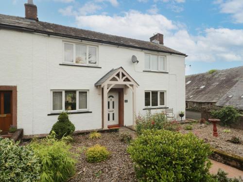 a white house with a garden in front of it at 3 Springfort Cottages in Penrith
