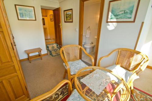 a room with two chairs and a table and a bathroom at Hospedaje Roiz in Suances