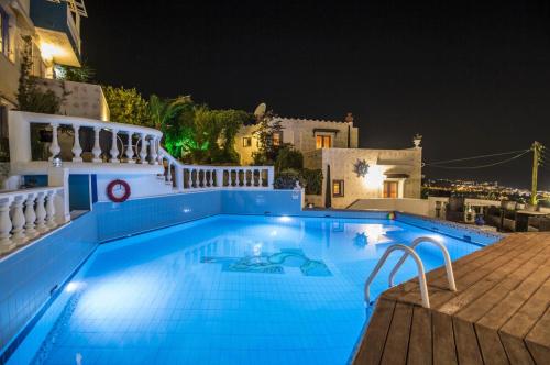 a swimming pool at night with a house in the background at One Private Studio full view in Hersonissos