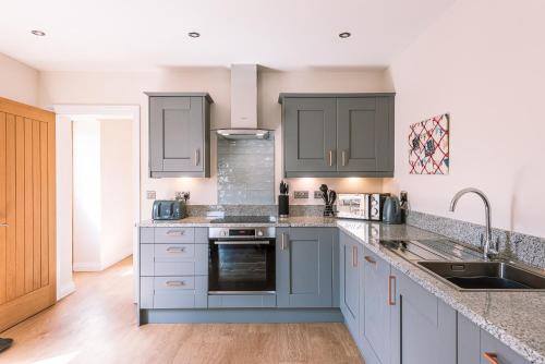 a kitchen with blue cabinets and a sink at Brecks Farm - The Mill in York