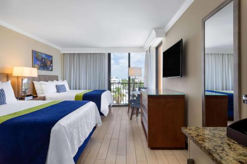 una camera d'albergo con due letti e un balcone di Wyndham Deerfield Beach Resort a Deerfield Beach