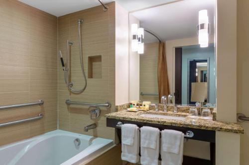 ein Bad mit einer Badewanne, einem Waschbecken und einer Dusche in der Unterkunft Wyndham Deerfield Beach Resort in Deerfield Beach