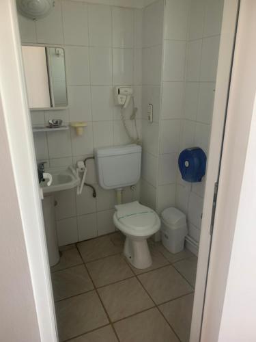 a small bathroom with a toilet and a sink at Motel Prietenia in Giurgiu