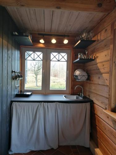 a kitchen with a sink and a window at Brīvdienu māja Mākoņi in Ratnieki