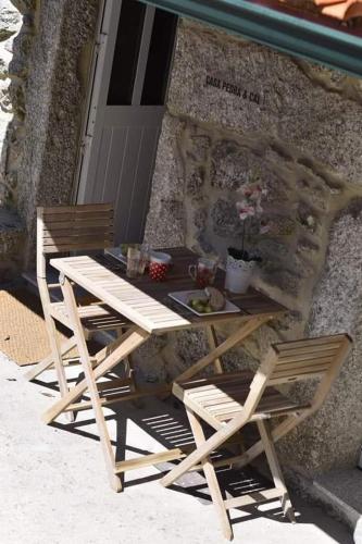 a picnic table and two chairs sitting next to a building at Casa Pedra & Cal in Paredes de Coura