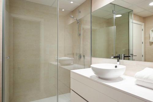 a bathroom with a sink and a glass shower at Green 12, 1 dormitorio, Oliva Nova, by Bookindenia in Oliva
