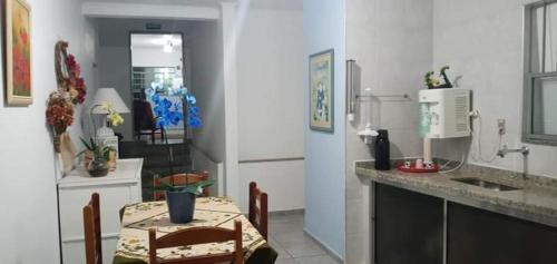 une cuisine avec une table et un comptoir avec une table et des chaises dans l'établissement Hotel Arbom, à Mogi-Guaçu