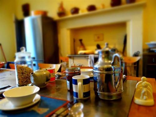 Heyford House في بيسستر: طاولة مطبخ مع صحون وغلاية شاي عليها