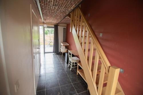 a hallway with a staircase in a house at De Grote Linde in Oostkamp