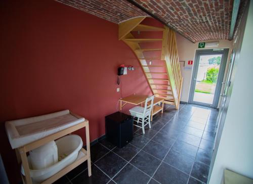a room with a staircase and a room with a table at De Grote Linde in Oostkamp