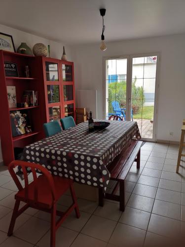 d'une table à manger et de chaises avec un chiffon de table à polka. dans l'établissement Chez Grace maison de vacances pour 8 personnes, à Wissant