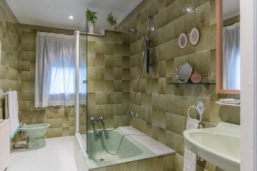 a bathroom with a green tub and a sink at Habitaciones en Villa Coliving Masía Rural in San Fausto de Campcentellas