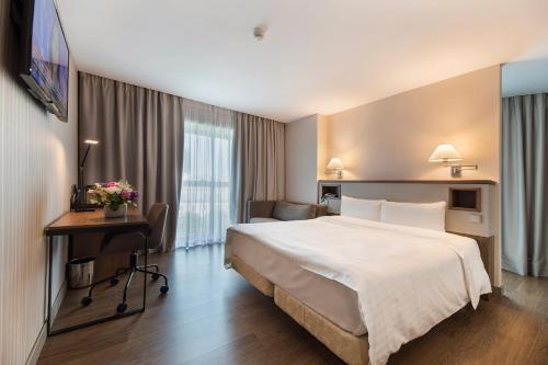 ブカレストにあるHotel CH Bucharestの大きなベッドとデスクが備わるホテルルームです。