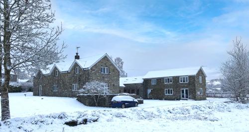 a house with a car parked in the snow at Maesyfelin Isaf Apartment in Llanybydder
