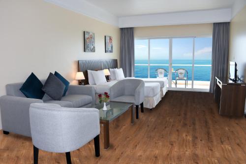 a hotel room with a bed and a view of the ocean at Ramada by Wyndham Beach Hotel Ajman in Ajman 