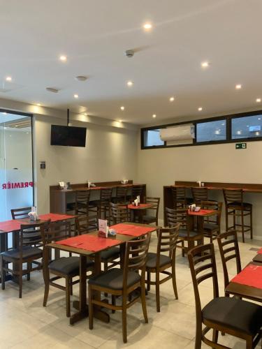 a dining room with wooden tables and chairs at Jandira Premiêr Hotel in Jandira