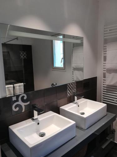 a bathroom with two sinks and a large mirror at Hôtel Club Port La Galère in Théoule-sur-Mer