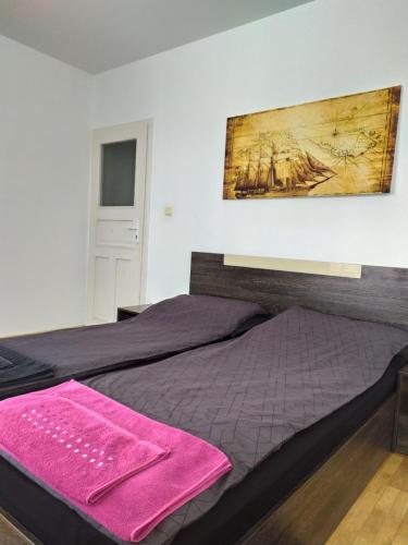 a bedroom with two beds and a painting on the wall at Apartament Bogoslovovi in Varna City