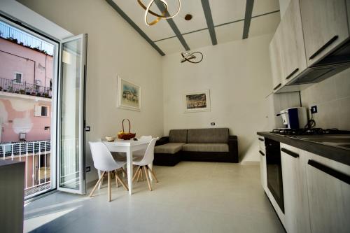 a kitchen and living room with a table and a couch at Ambra Apartment in Ischia