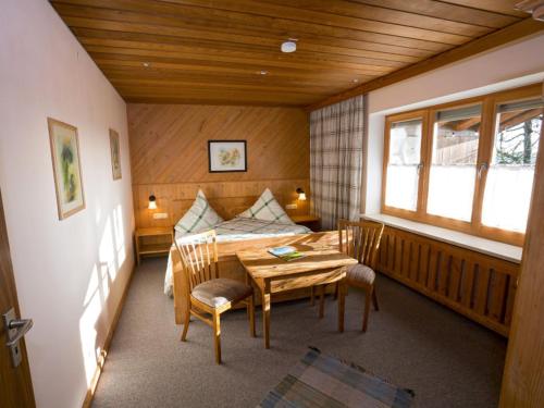 een kamer met een tafel en stoelen en een bed bij Lapperhof in Waging am See
