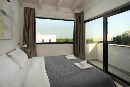 a bedroom with a bed and a large window at Sea View Villa Cala Royal in Krnica