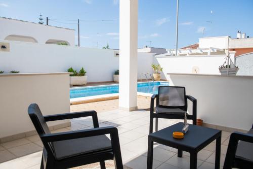 a patio with chairs and a table and a pool at Villa Gallese in Lendinuso