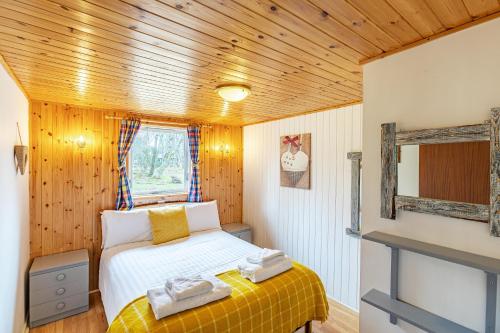 a bedroom with a bed with towels on it at Heather Lodge 17 with Hot Tub in Belladrum