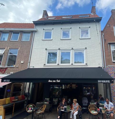 a group of people sitting at tables in front of a building at Anna van Chiel in Vlissingen