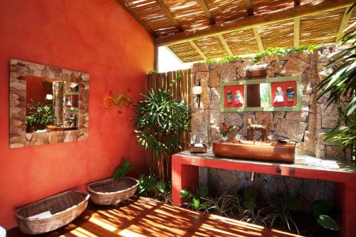 a bathroom with a sink and a stone wall at Casa 10 -Txai Resort in Itacaré