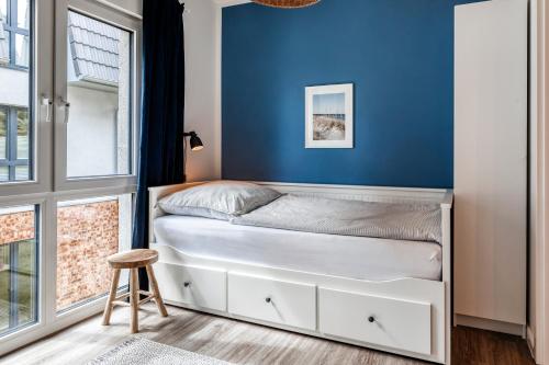 a bedroom with a bed with a blue wall at 54' Nord Damp in Damp