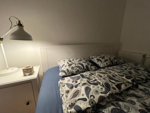 a bed with two pillows and a lamp on a table at Like Home 1 in Sarajevo
