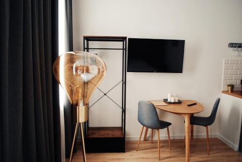 a room with a table and a chair and a lamp at BOOGIE Home Kamienica Łódzka in Łódź