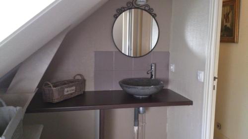 une salle de bain avec un lavabo et un miroir dans l'établissement Appartement Autour de la Rose, à Honfleur
