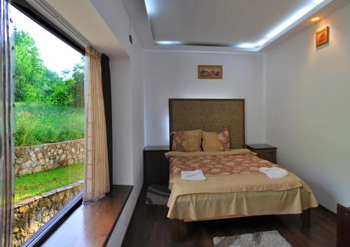 ein Schlafzimmer mit einem Bett und einem großen Fenster in der Unterkunft Montana in Suceviţa
