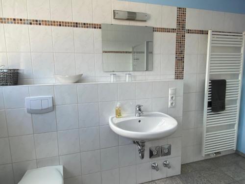 a white bathroom with a sink and a mirror at Weinquartier Kröv in Kröv
