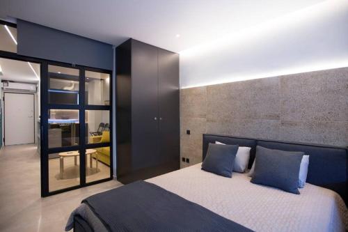 a bedroom with a large bed with blue pillows at City Center Modern Renovated Apartment in Athens