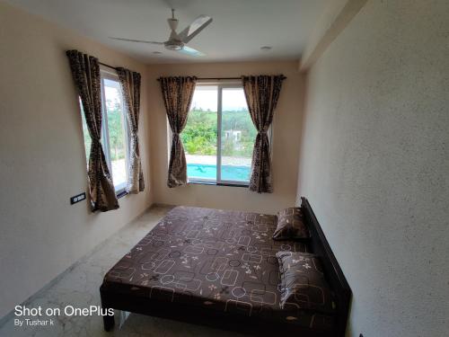 a bedroom with a bed and a window at ROYAL MEADOWS IGATPURI 2BHK POOLSIDE VILLA in Igatpuri