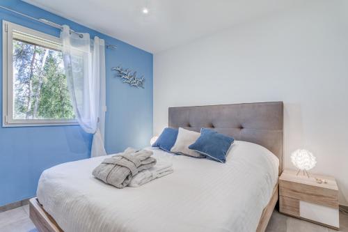 ein blaues Schlafzimmer mit einem Bett mit Handtüchern darauf in der Unterkunft Les Roseaux in Sanchey