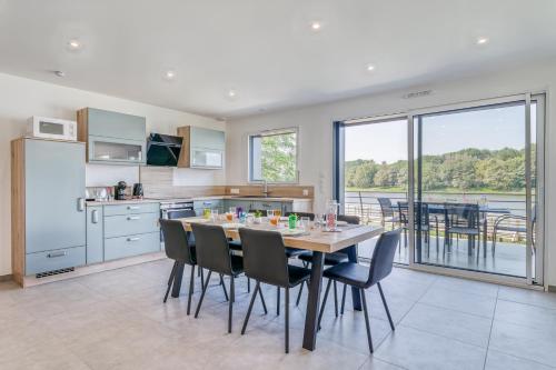 une cuisine et une salle à manger avec une table et des chaises dans l'établissement Les Roseaux, à Sanchey