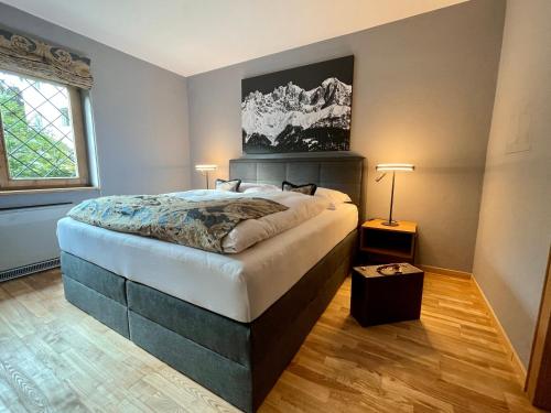 a bedroom with a large bed and two lamps at Kitzbühel Beach Chalet " Ski-in & Ski-out " in Kitzbühel