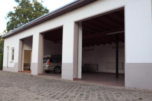 a white garage with a car parked in it at Leuna - Mechanicsville in Bad Dürrenberg