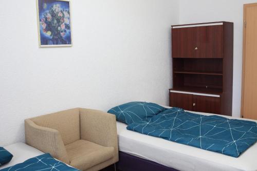 a small bedroom with a bed and a chair at Leuna - Mechanicsville in Bad Dürrenberg