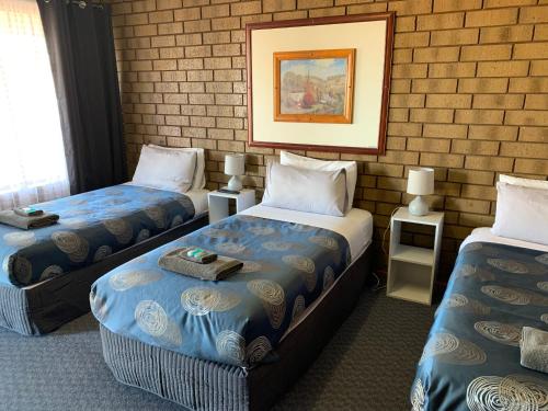 a room with two beds and a picture on the wall at Airport Whyalla Motel in Whyalla