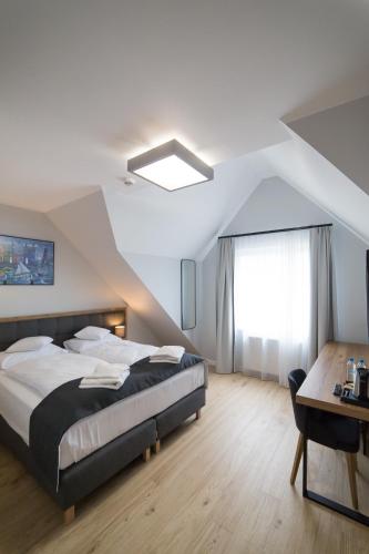 a bedroom with a large bed and a table at Villa Aura in Świnoujście