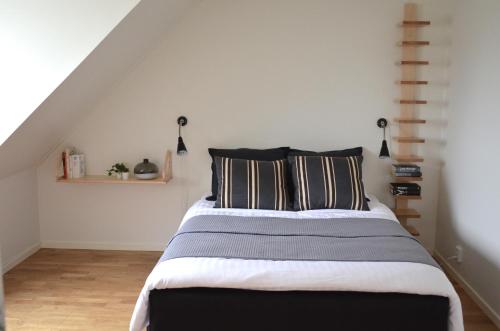 Schlafzimmer mit einem Bett mit schwarzen und weißen Kissen in der Unterkunft Forskarhotellet in Lund