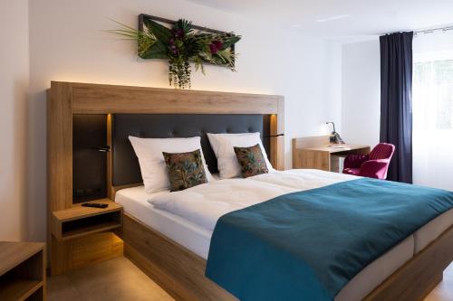 a bedroom with a large bed with a wooden headboard at Bed and Breakfast - Homburg am Main in Homburg