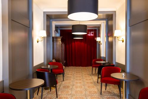 a restaurant with red chairs and tables and a red curtain at Luxstay Karben - Self-Check-In in Karben