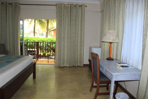 a bedroom with a bed and a table with a lamp at Bojo Beach Resort in Bortianor