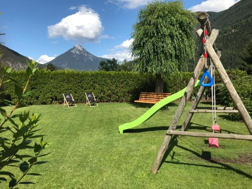 a swing set in a yard with a mountain in the background at Apart Alp Line in Mils bei Imst