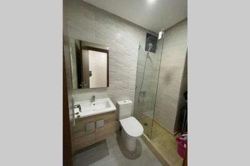 a bathroom with a toilet and a sink and a shower at Superbe appartement en front de mer haut standing in Kenitra